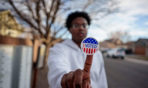 Young African-American voter displays voting sticker